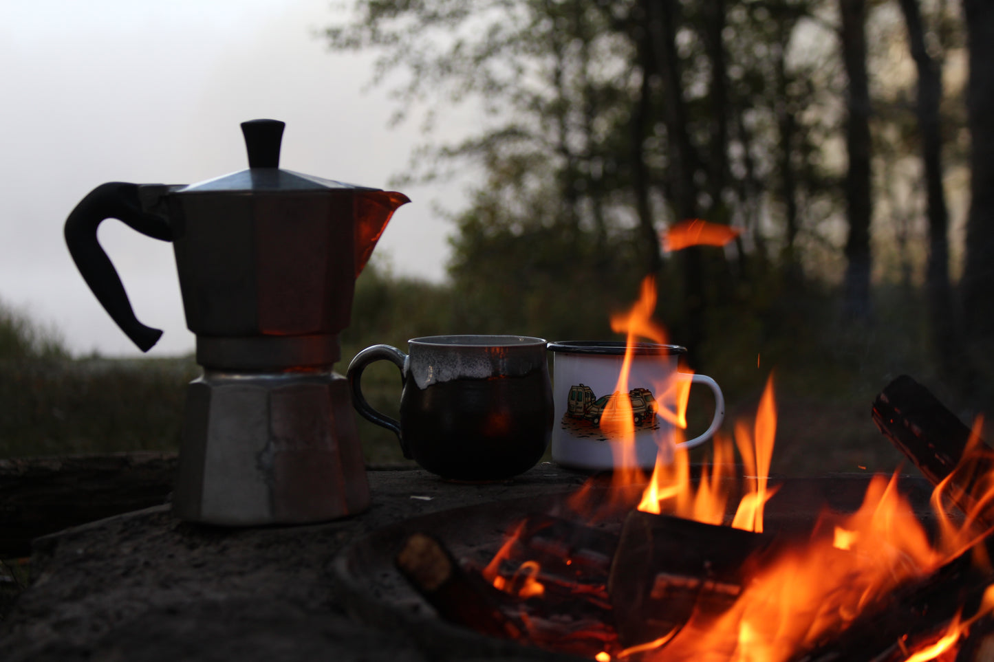 Kaffekanna och två koppar vid en lägereld